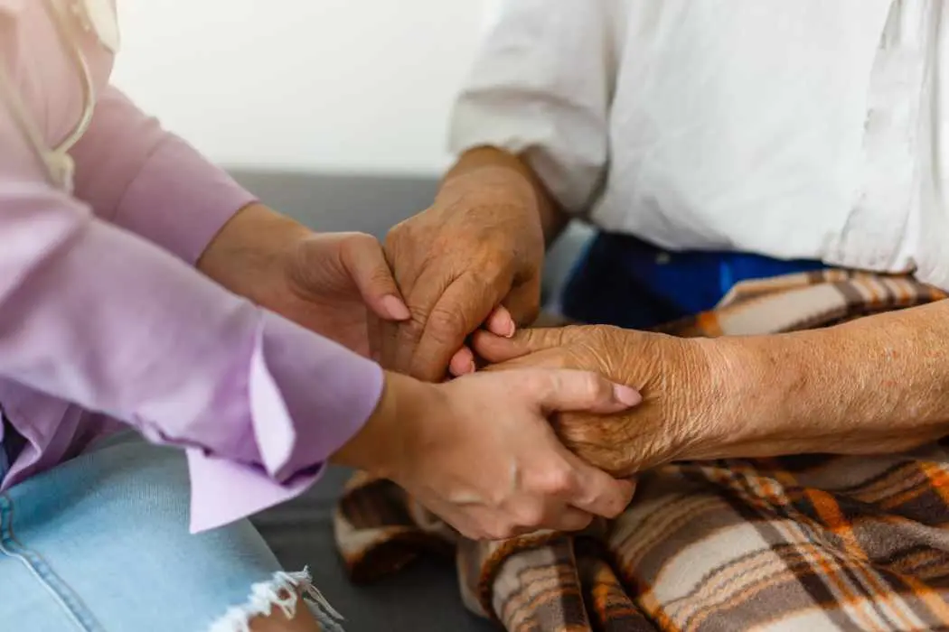 Man and woman holding hands talking about what is included in hospice care in El Paso and Las Cruces.