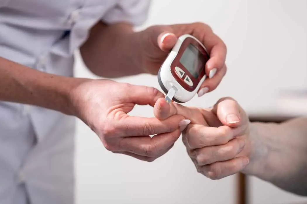 Home health nurse taking glucose reading performing diabetes home health care