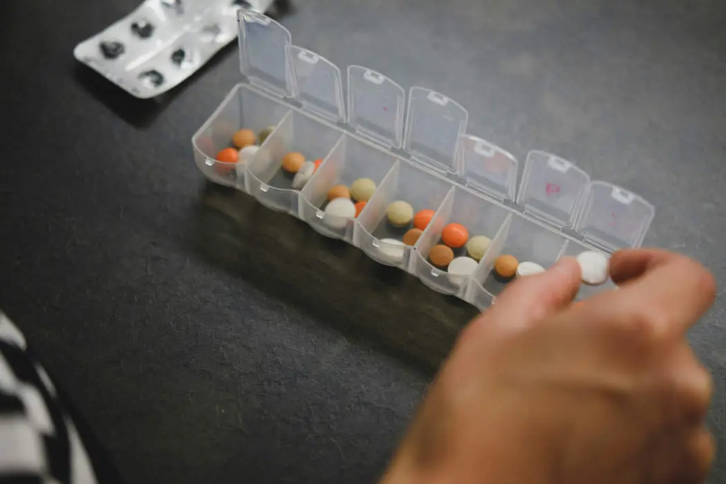 Pills being counted and put into pill box, medication management at home.