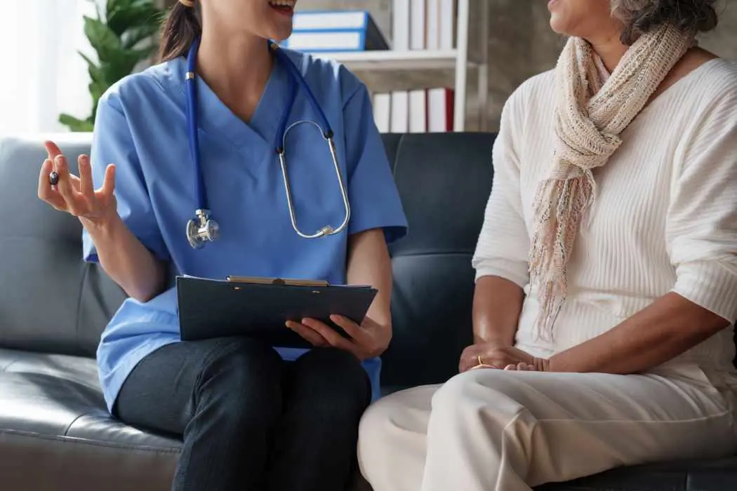 A woman nurse talking to a senior woman about primary care at home in El Paso