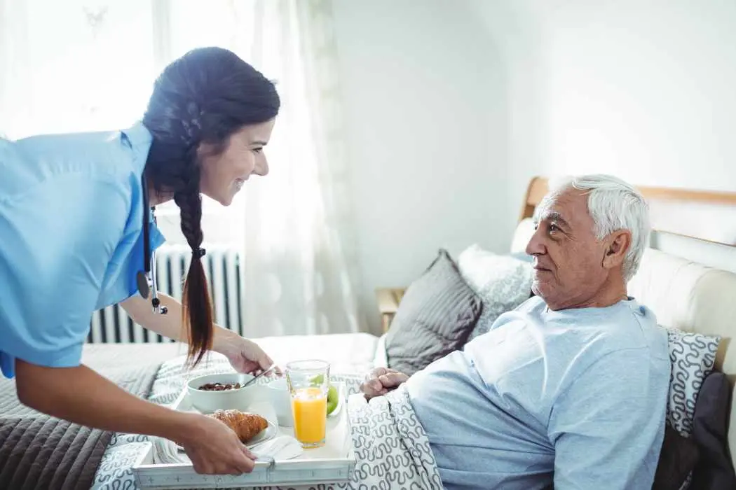 Nurse with male cancer patient during palliative care.