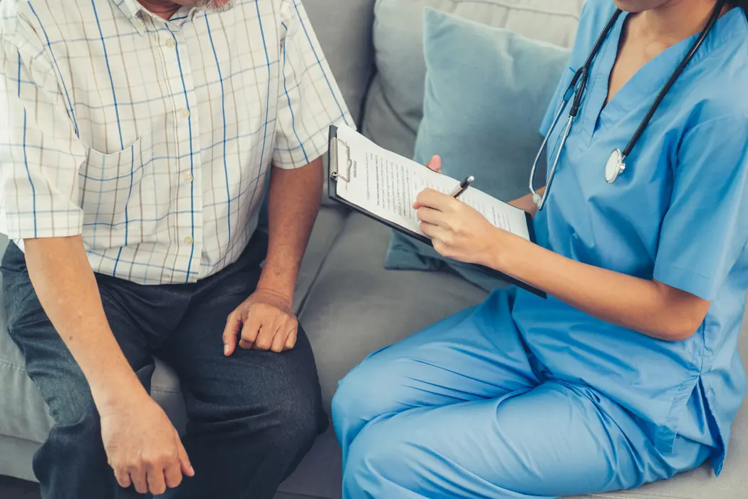 Nurse with clipboard answering questions about hospice.