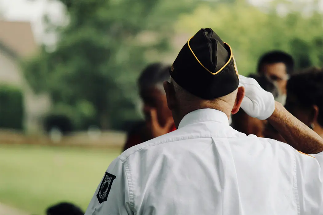 Veteran in uniform saluting.