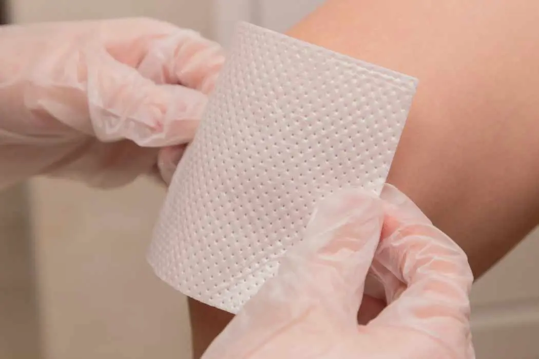 Placing a bandage on a wound after seeking a wound care specialist in El Paso, Texas.