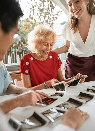 Elderly lady smiling looking at photos with family while in hospice care