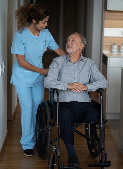 Man in wheelchair getting pushed by nurse while in hospice care in Chaparral, NM