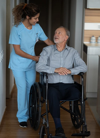 Man in wheelchair getting pushed by nurse while in hospice care in Chaparral, NM