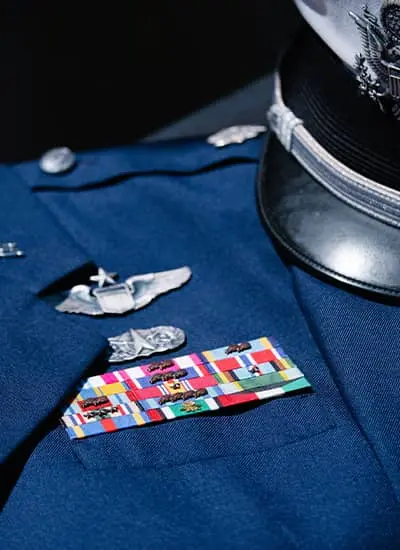 Army uniform with service ribbons and pins.
